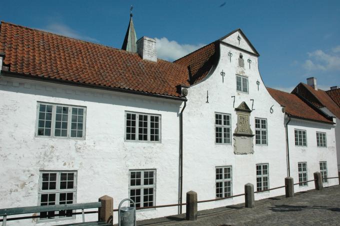 Hertug Hans' Hospital set fra gadesiden. I baggrunden anes kirketårnet.