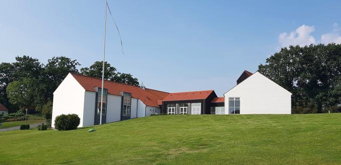Høje Kolstrup Kirke, toppen af klokkehuset anes i baggrunden. Foto fra 2019.