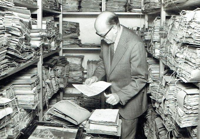 Olav Christensen, der var arkivleder i årene 1946-1973, leder i arkivalierne. Foto fra ca. 1970.