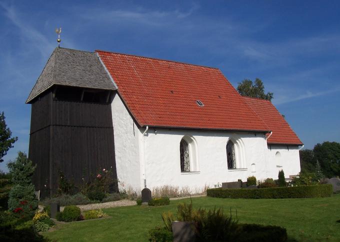 Brodersby Kirke med den tilføjede klokkestabel i træ, der fungerer som vesttårn. Brodersby Kirke med den tilføjede klokkestabel i træ, der fungerer som vesttårn.