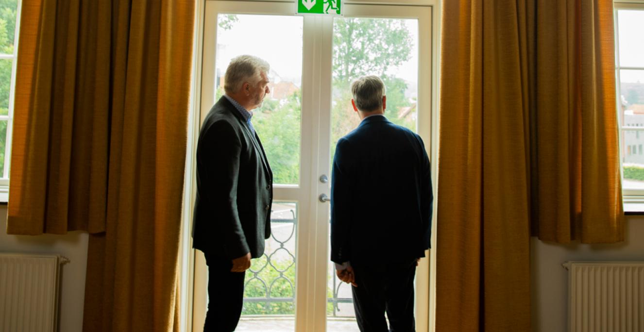 Fotografen ville gerne have Hinrich Jürgensen og Jens A. Christiansen til at gå ud på balkonen, hvor H.P. Hanssen den 17. november 1918 – en uge efter Første Verdenskrigs afslutning – holdt tale til ca. 3.000 sønderjyder. Men Hinrich Jürgensen og Jens A. Christiansen er enige om at sige nej til fotografen: ”Vi vil ikke støde nogen”, siger de. Og Hinrich Jürgensen tilføjer: ”Det er en succes i sig selv, at vi er her på Folkehjem sammen.”