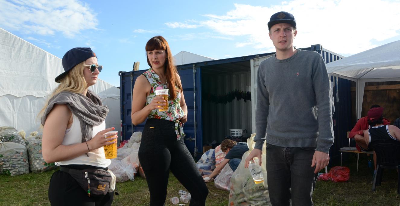 Bag pantboden kan man slappe af ude og inde i cafeteria-teltet. “Der er endda en hængekøje i containeren, som man kan tage sig en power nap i”, siger Wienke Reimer (i midten), der er med i arbejdsgruppen, der har organiseret pantboden.