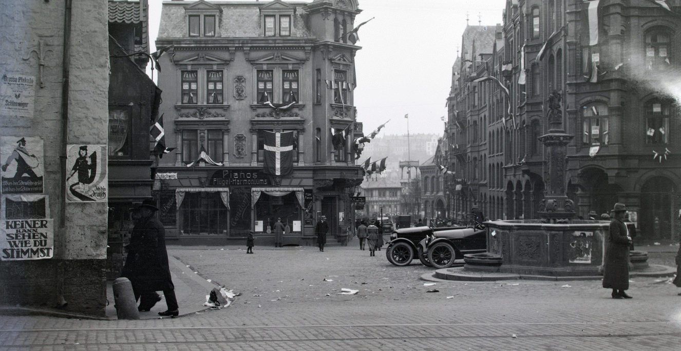Nørretorv i Flensborg. Hvis man trådte ud af døren til Flensborg Avis' bladhus på afstemningsdagen den 14. marts 1920, var dette synet, man mødte: Nørretorv smykket med danske og slesvig-holstenske flag, afstemningsplakater og et torv, der flød med flyveblade. Det var også her, foran avisens lokaler, der blev samlet til demonstration, da den tyske sejr var en kendsgerning. Nørretorv i Flensborg. Hvis man trådte ud af døren til Flensborg Avis' bladhus på afstemningsdagen den 14. marts 1920, var dette synet, man mødte: Nørretorv smykket med danske og slesvig-holstenske flag, afstemningsplakater og et torv, der flød med flyveblade. Det var også her, foran avisens lokaler, der blev samlet til demonstration, da den tyske sejr var en kendsgerning.
