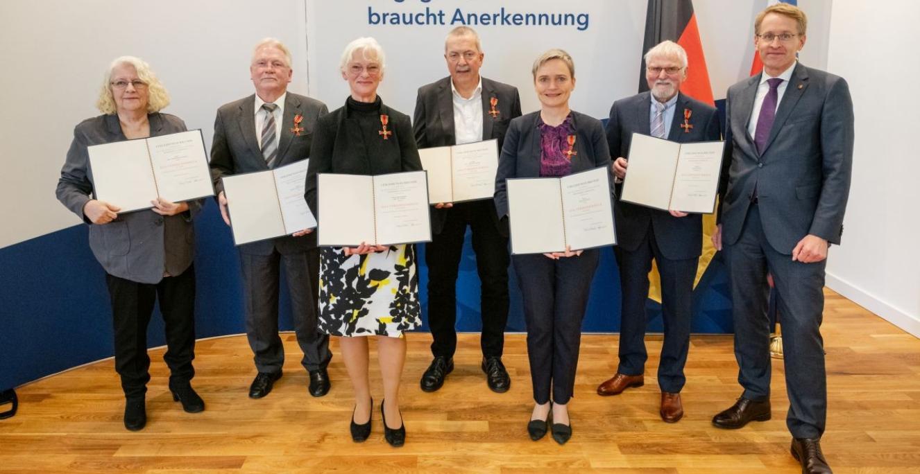 Ved overrækkelsen af fortjenstmedaljerne ses de slesvig-holstenske modtagere Anke Timmermann-Grell, Hans-Ulrich Vorlauf, Ute Thyen, Theodor Siebel, Gesa Retzlaff, Jürgen Kunze og ministerpræsident Daniel Günther (CDU). Ved overrækkelsen af fortjenstmedaljerne ses de slesvig-holstenske modtagere Anke Timmermann-Grell, Hans-Ulrich Vorlauf, Ute Thyen, Theodor Siebel, Gesa Retzlaff, Jürgen Kunze og ministerpræsident Daniel Günther (CDU).