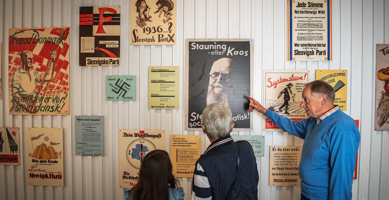 Billede af personer der kigger på gamle plakater