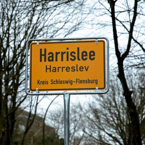 Grænsekommunen Harreslev har efter 15 års politisk kamp fået byskilte på både dansk og tysk. Grænsekommunen Harreslev har efter 15 års politisk kamp fået byskilte på både dansk og tysk.