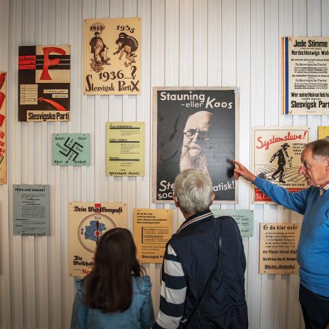 Billede af personer der kigger på gamle plakater