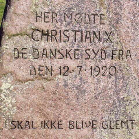 Mindestenen ved krydset Sønderborgvej og Flensborgvej/Aabenraavej i Kruså blev sat på det sted, hvor kong Christian den Tiende 12. juli 1920 havde mødt danske sydslesvigere, som efter afstemningsresultaterne i 1920 forblev en del af Det Tyske Rige. 