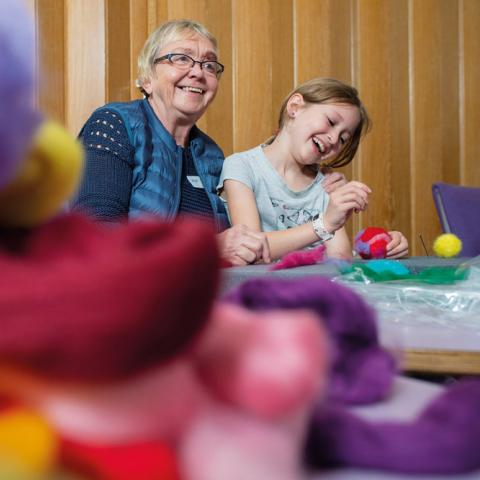 Der bliver leget og nørklet og talt både dansk og tysk på familie-sprog festival i Sydslesvig. Her er det otte-årige Alma Eget Gessø Hansen, der hjælper mormor, Bodil Gessø Hansen, der aldrig har prøvet at filte før, med julekuglen. 