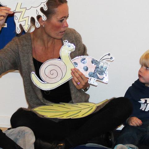 ”Det gælder om at inkludere børnene i sproglige fællesskaber, hvor de kan lære af og med hinanden”, siger Carina Løngaa, pædagogisk leder i det dansk-tyske børnehus, der her på dansk fortæller om Mariehønen Evigglad, mens hendes kollega oversætter til tysk. 