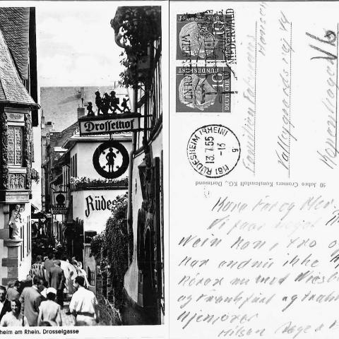 Postkort sendt fra Rüdesheim am Rhein d. 13. juli 1955 til familien Fabricius Hansen i København. Teksten, der er signeret ‘Aage og Frida’, fortæller om, at “vi faar noget Rhein Wein, kan I tro” og “vi har endnu ikke hjemve”.