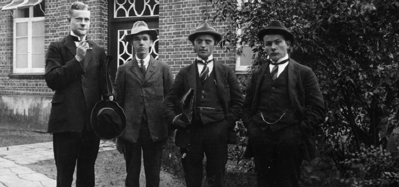 De fire unge lærerstuderende var en del af de i alt 33 unge mænd, der ankom til Jelling i 1919. De 33 studerende kom fra henholdsvis seminarierne i Tønder og Haderslev, som dengang var en del af Preussen. 