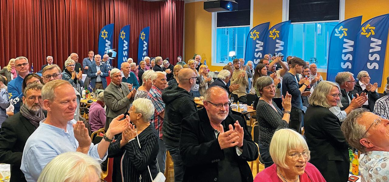 “SSW har igennem 75 år vist, at det er relevant og i praksis uundværligt som mindretallets politiske repræsentant. Selv om danske sydslesvigere også er engageret i andre politiske partier og til dels varetager politiske hverv i parlamenter fra lokalt plan til Europa-Parlamentet, hvor de støtter og taler mindretalspolitiske interesser op, er SSW fortsat mindretallets uanfægtede politiske stemme. Der findes intet alternativ, selv om CDU, De Grønne og SPD har defineret meget mindretalsvenlige politikker”, skri