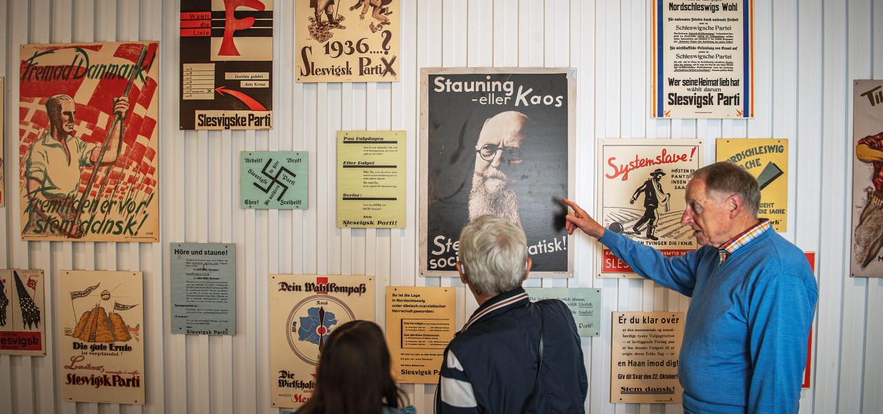 Billede af personer der kigger på gamle plakater