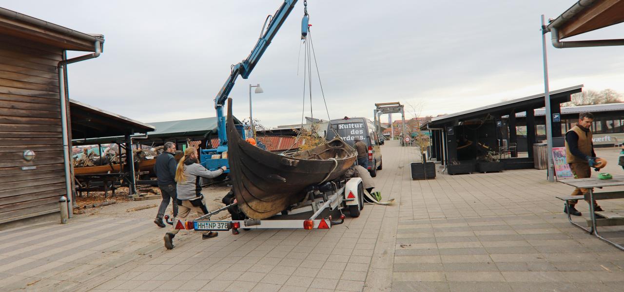 Vikingeskibet Erik Styrimathr bliver løftet fra traileren til en plads på Vikingeskibshallens værft.