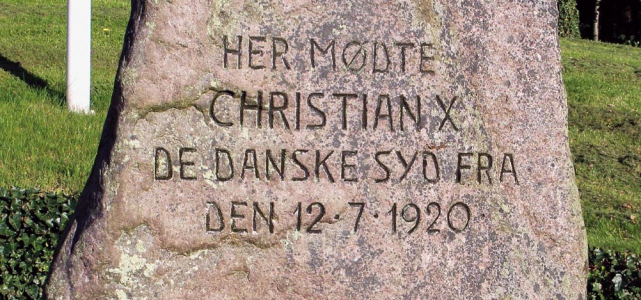 Mindestenen ved krydset Sønderborgvej og Flensborgvej/Aabenraavej i Kruså blev sat på det sted, hvor kong Christian den Tiende 12. juli 1920 havde mødt danske sydslesvigere, som efter afstemningsresultaterne i 1920 forblev en del af Det Tyske Rige. 
