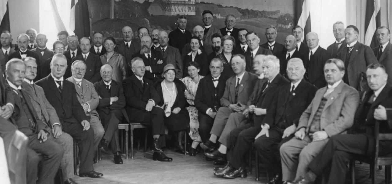 Grænseforeningens hovedstyrelse forsamlet i Aarhus i 1929 med billede af Dybbøl Mølle i baggrunden. Nummer tre fra venstre (siddende) er rektor H.P. Hansen, der var formand for Grænseforeningen fra 1926 til sin død i 1942. Axel Johnsen fremhæver H.P. Hansen som en af de formænd, der havde succes med at finde en linje i krydsfeltet mellem et til tider meget aggressivt Tyskland, et stærkt defensivt Danmark og et mindretal i Sydslesvig, der hele tiden drømte om at komme hjem til Danmark.