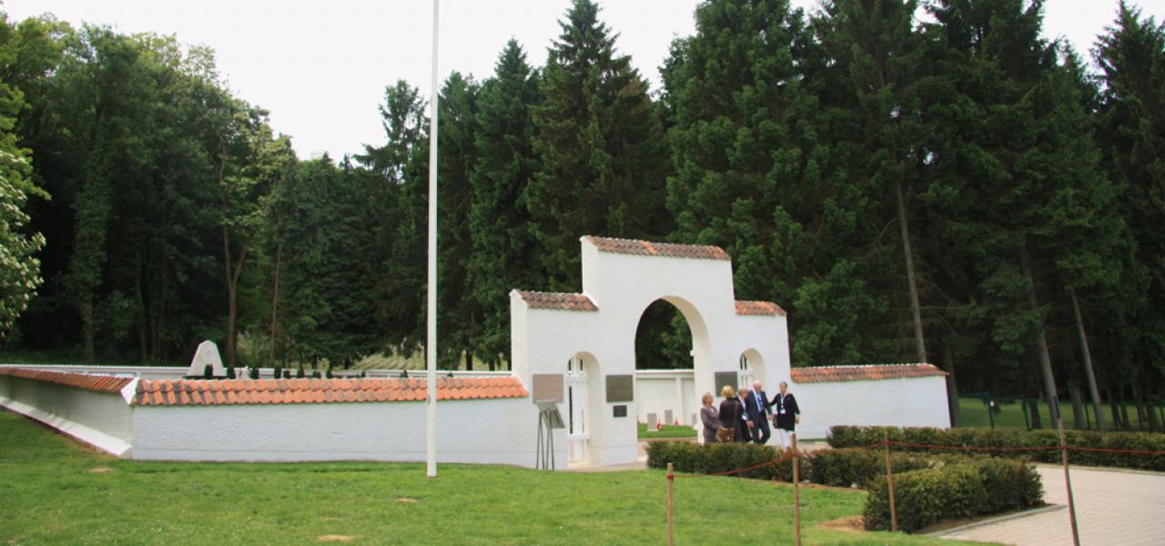 I traditionel dansk stil er den hvide mur omkring den sønderjyske kirkegård i Braine beklædt med røde teglsten.